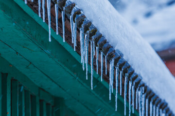 Icicles on the roof of the house. Danger of falling