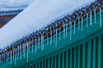 Icicles on the roof of the house. Danger of falling