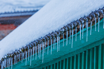 Icicles on the roof of the house. Danger of falling
