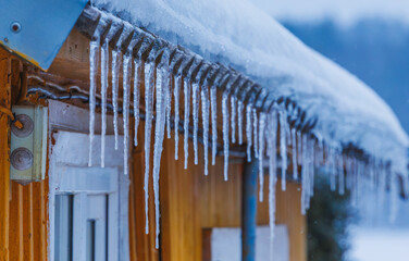 Icicles on the roof of the house. Danger of falling