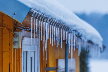 Icicles on the roof of the house. Danger of falling