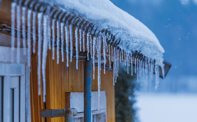 Icicles on the roof of the house. Danger of falling