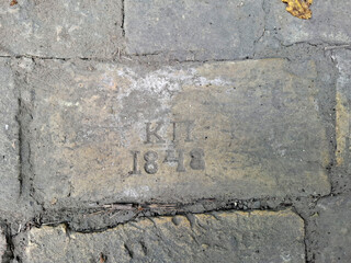 An old brick from 1848 on an old sidewalk in the old Podol district in Kyiv, Ukraine
