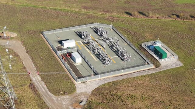 Aerial drone view of a high voltage electrical substation with metallic busbars and overhead power lines in Luton UK