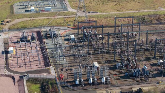 The Great Grid Upgrade aerial view of Sundon Supergrid substation near Luton UK featuring 400kV transformers and high-voltage pylons.
