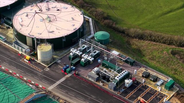 Close up aerial drone view of a biogas green energy plant near Northampton UK showcasing anaerobic digesters and sustainable agricultural waste power.