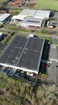 Aerial drone view of a large modern data center facility featuring extensive roof-mounted solar panel arrays for sustainable AI power.