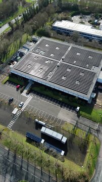 Aerial drone view of a large modern data center facility featuring extensive roof-mounted solar panel arrays for sustainable AI power.