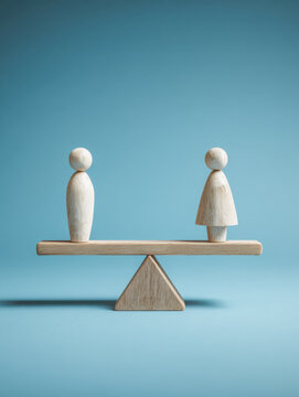 Wooden male and female figures balanced equally on a seesaw against a blue background symbolizing gender equality and balance in society and relationships