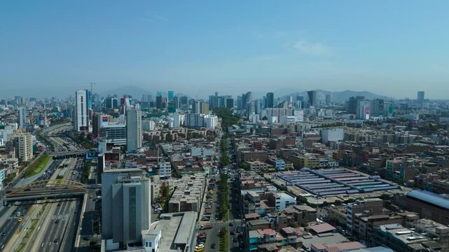 Cinematic drone shot of Lima, large South American city during bright summer daylight.