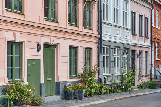 Helsingborg, Sweden - 12 August 2025: View of pastel-colored buildings stand shoulder-to-shoulder, their vibrant facades creating a picturesque streetscape bathed in soft light.