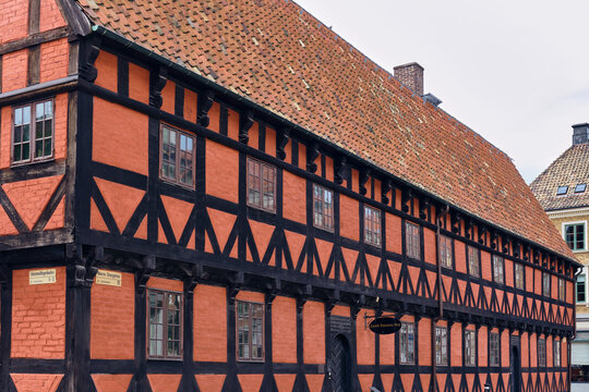 Helsingborg, Sweden - 12 August 2025: View of a historic timber-framed building with vibrant red walls and dark wooden beams, reflecting a timeless architectural charm.