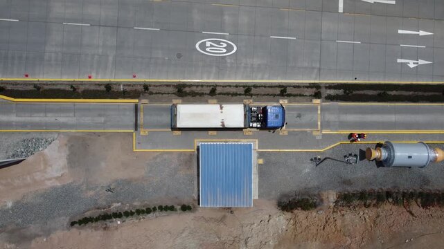 Aerial top view of tanker truck weighing on scale at weighbridge
