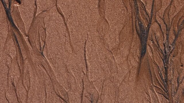 Magical with Black Sand Beaches on multicolored Hormuz Island, Iran. The dark sand from heavy minerals such as hematite, ilmenite, and magnetite, creating striking textures along the shoreline.