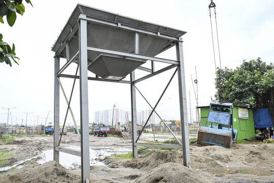 Dhaka, Bangladesh - 11 September 2025: View of a modern metal structure stands starkly against the muddy ground, hinting at urban development amidst the city's evolving landscape.