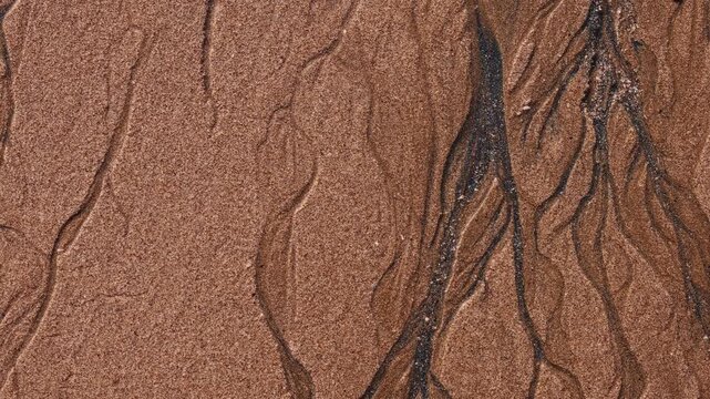 Magical with Black Sand Beaches on multicolored Hormuz Island, Iran. The dark sand from heavy minerals such as hematite, ilmenite, and magnetite, creating striking textures along the shoreline.