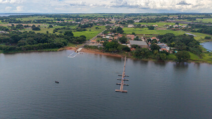 Obraz premium Aerial view of a serene lake with a small town and lush green landscape in the background