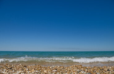 Aquamarine summer sky above sea waves