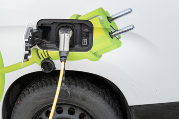 Fototapeta premium Electric vehicle charging at public station for sustainable energy