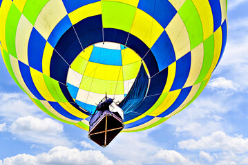 Fototapeta premium Colorful hot air balloon flying over blue sky with white clouds