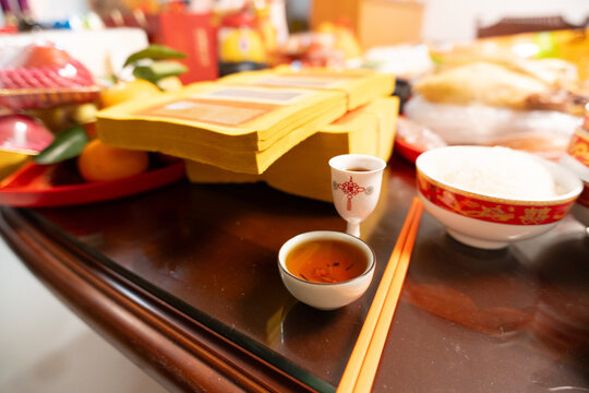 Traditional Chinese altar setup with incense, tea, offerings, and ceremonial items on wooden table