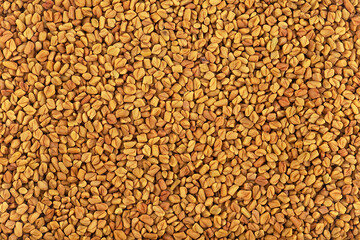 Fototapeta premium Heap of natural aromatic fenugreek seeds as background, healthy food. Culinary ingredient. Fragrant grains.