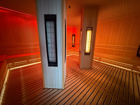 Infrared sauna cabin with central heaters and wooden floor. Heat therapy, recovery session, wellness routine, detox process, relaxation environment