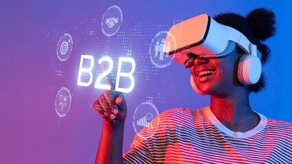 A joyful woman immersed in virtual reality technology explores business-to-business concepts with...