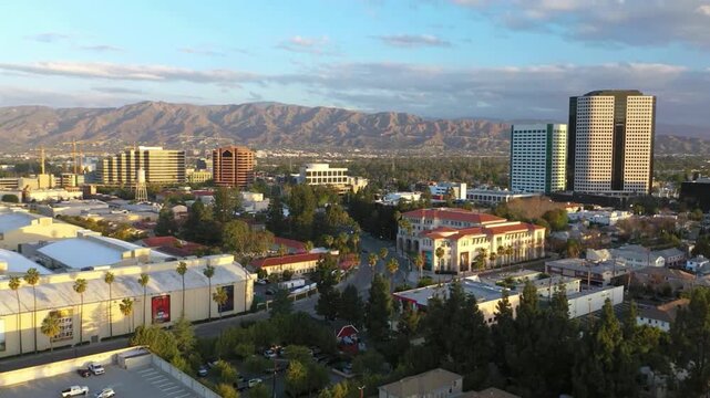 Aerial shot of the Burbank city with Verdugo Mountains at sunset. city's suburban layout and commercial buildings, with the rugged Verdugo Mountains rising in the background. 