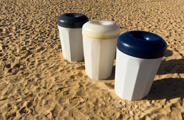 Three Colorful Plastic Waste Containers On Wheels For Separate Collection Of Garbage. Containers For Temporarily Storing Waste. Dustbins, Garbage Cans, Trash Cans On Sea Ocean Coast Beach
