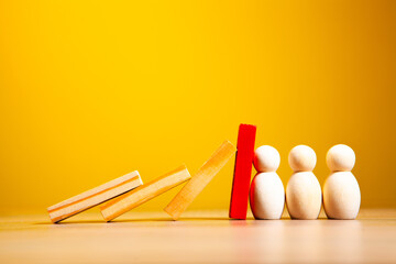 Wooden figures of people and red dominoes on a yellow background