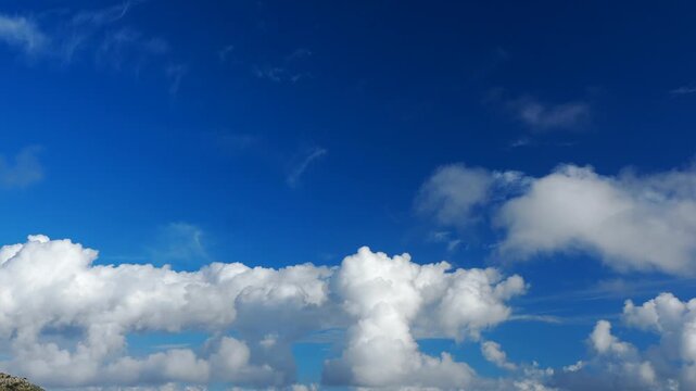 4K timelapse of cumulus and towering cumulus clouds billowing and moving dynamically across a deep blue sky. Dramatic atmospheric cloud formations with strong vertical development, ideal for weather, 