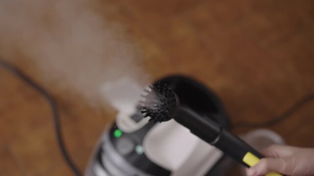 Steam cleaner appliance expelling pressurized vapor from brush head attachment, providing deep sanitation and deodorizing surfaces for spotless, chemical-free clean using pure water and heat.