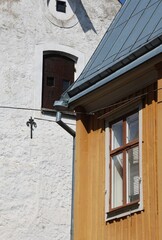 Traditional wooden house facade with window and white plaster wall