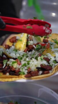 Slow Motion Salsa Verde Poured Over Al Pastor Tacos &ndash; Vertical Close Up Street Food in Southern California