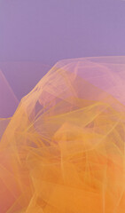 Bright orange tulle fabric on purple background.  Abstract transparent material curve wave.