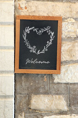 welcome tafel mit herz aus blumenranken