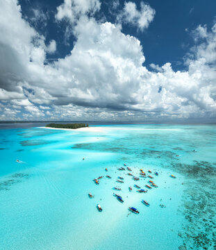 Aerial view of tropical sandbank, sea, tourist boats in turquoise water near Mnemba Island, Zanzibar, Tanzania. Crystal clear Indian Ocean, coral reef, white sandy beach, summer travel. Top drone view