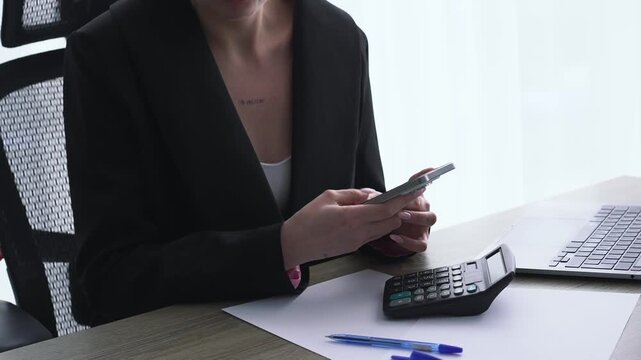 A girl in a fois with a mobile phone in her hands is typing an SMS