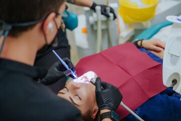 The doctor treats the patient's teeth. The girl is lying in the dentist's chair. Oral care at the dentist. Dental instruments.