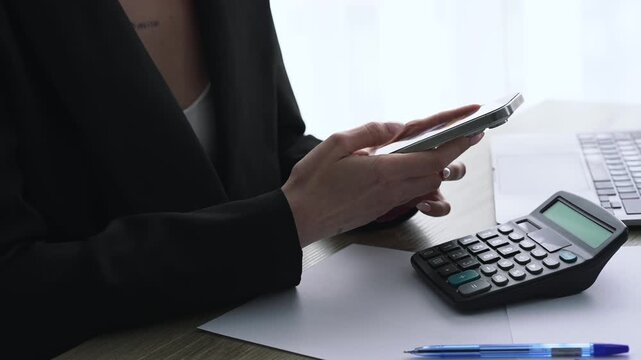 A businesswoman holding a mobile phone and texting online.
Online communication.
A woman enters a PIN code on a smartphone.
