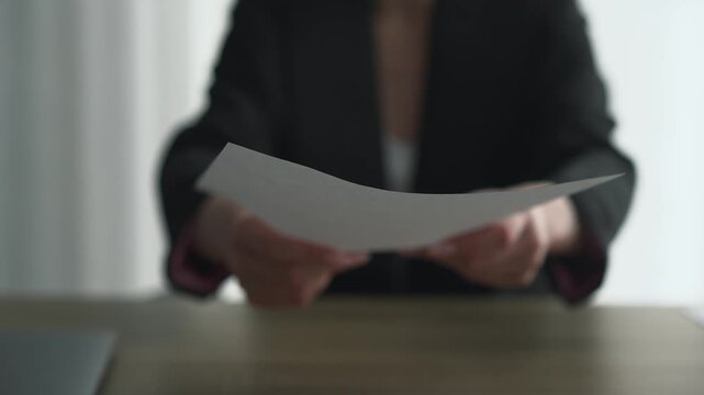 A secretary signs documents in an office.
Paperwork in the office.
A businesswoman holding documents.
Employment contract