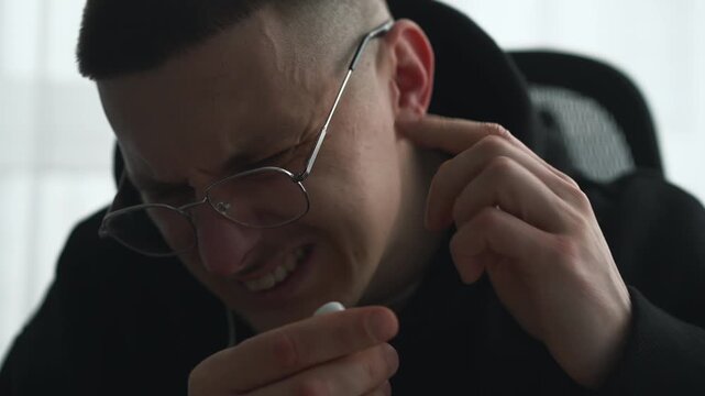 Ear infection due to listening to loud music on headphones.
A person removes headphones due to discomfort.
Damage from headphones