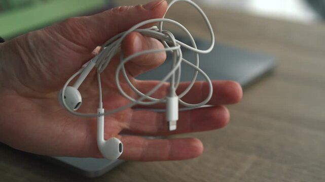 A person holding small wired headphones.
Modern smartphone gadgets