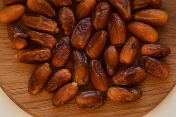 Obraz premium Dried medjoul jumbo dates.Dried dates fruits on the wooden surface. Arabic food for the ramadan. Food and health background. Delicious fresh organic dates.