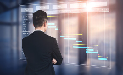 Fototapeta premium A business professional inspects a project management Gantt chart displayed on a digital screen, showcasing timelines and tasks in a modern office environment. Tessel