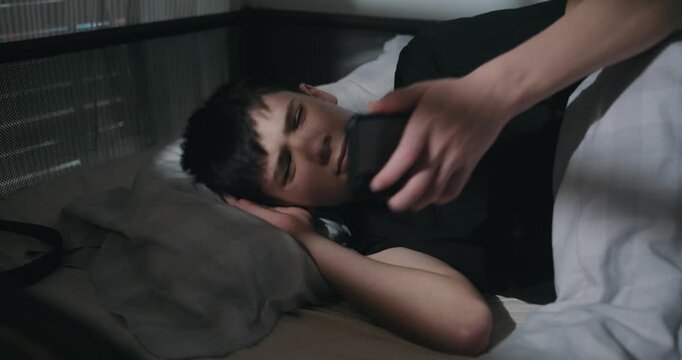 Teenage Boy Wakes Up and Immediately Checks His Smartphone in Bed