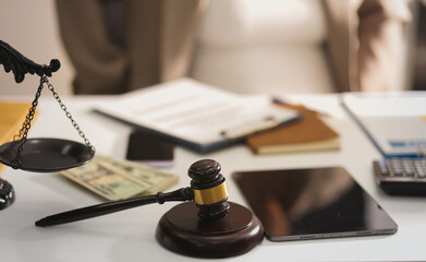 Judge gavel with Justice lawyers having team meeting at law firm in background. Notary with client in office
