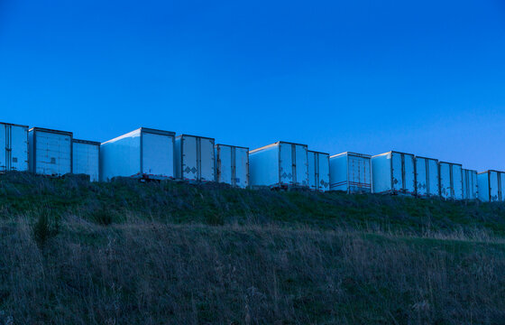 Canada, BC, Delta.  Line of truck trailers along the ridge of a hill.  Trucking company's parking area.