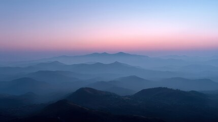 Obraz premium Serene Layered Mountain Landscape at Dawn with Soft Pink and Blue Sky Over Horizon Captured in Early Morning Light